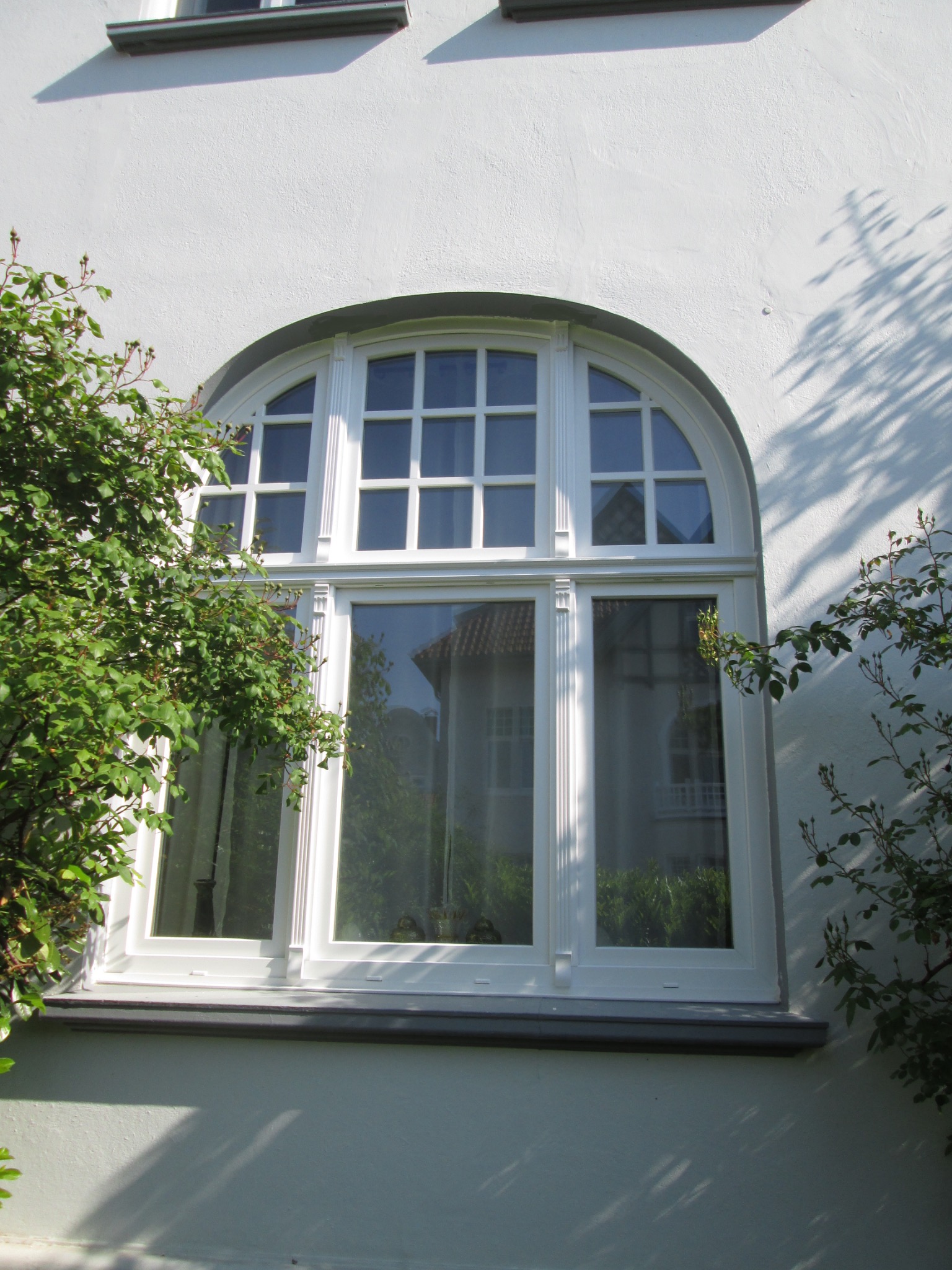 Aufwendig gegliedertes Rundbogenfenster im Altbau
